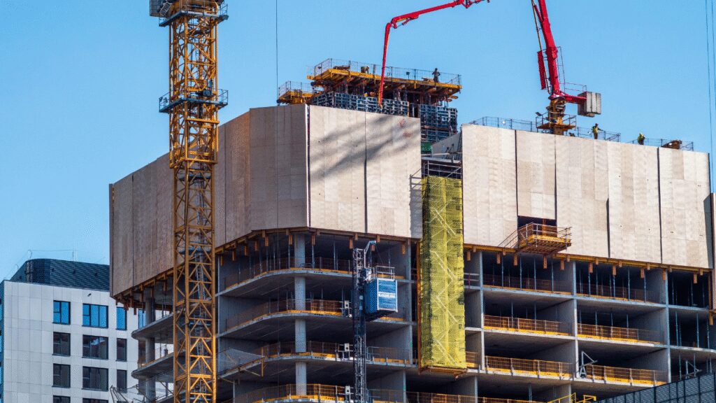 A beautiful modern home under construction in Calgary with cranes and workers, showcasing a mix of traditional and contemporary architecture